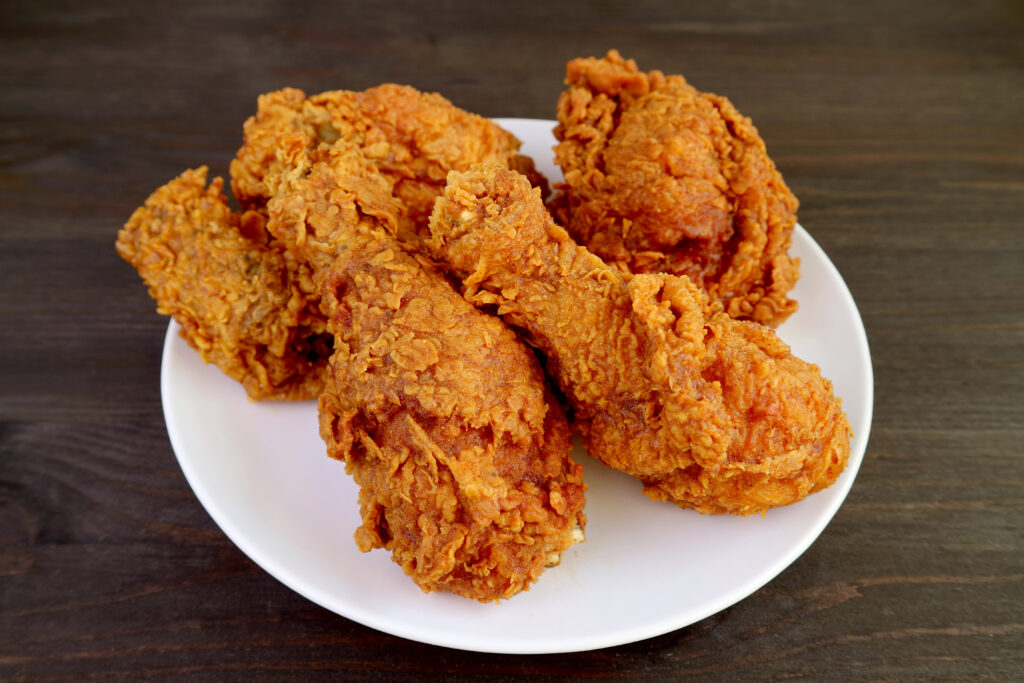 Closeup a Plate of Mouthwatering Golden Brown Crunchy Fried Chickens on Wooden Table
